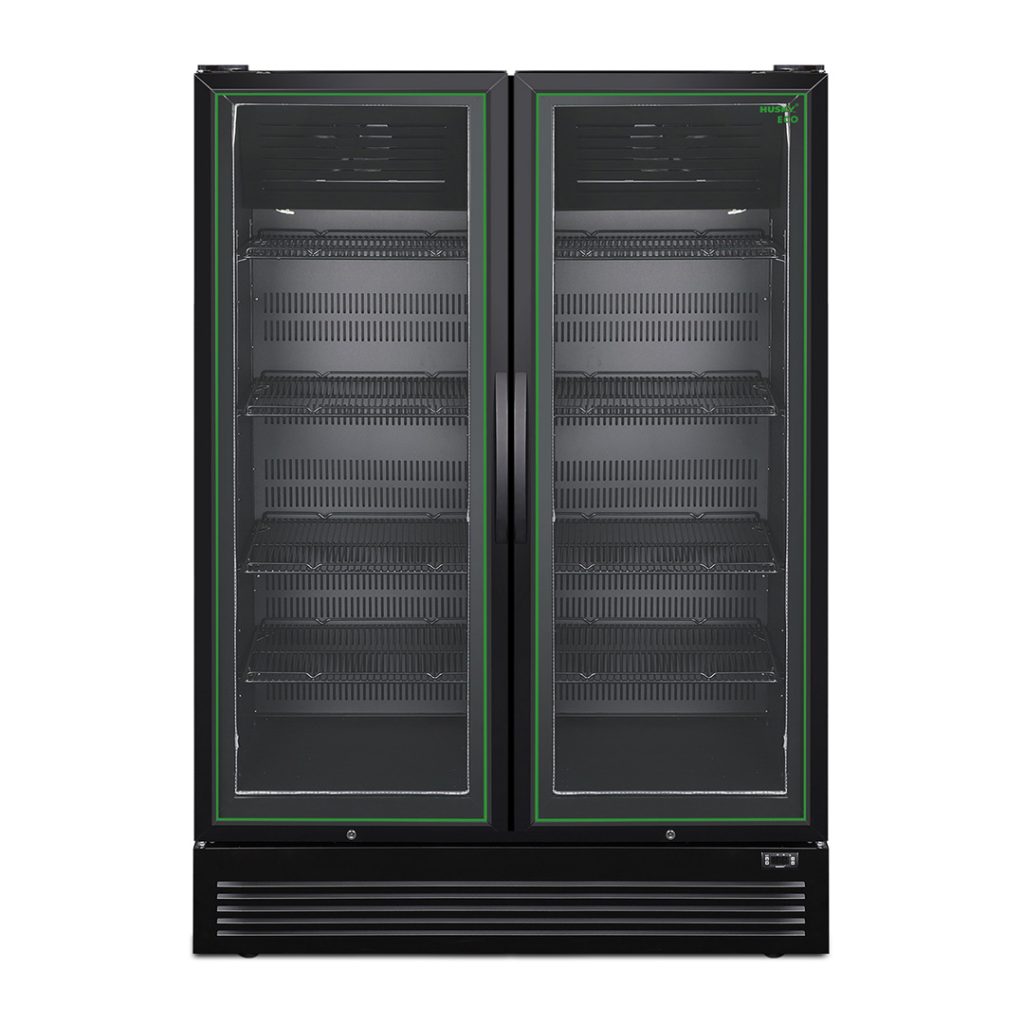 A large, black double-door commercial refrigerator stands idle, with empty glass shelves visible through transparent doors. The setting appears to be industrial or retail-oriented.